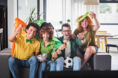 Çok ırklı Gençler Eğleniyor, TV 'de futbol maçı izliyorlar. İrlanda için tezahürat.