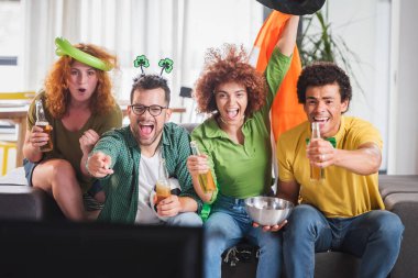 Çok ırklı Gençler Eğleniyor, TV 'de futbol maçı izliyorlar. İrlanda için tezahürat.