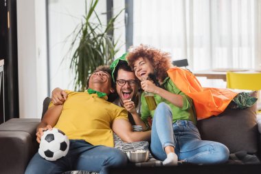 Çok ırklı Gençler Eğleniyor, TV 'de futbol maçı izliyorlar. İrlanda için tezahürat.