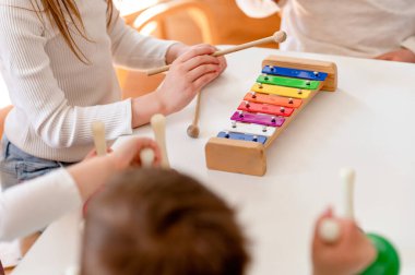 Anaokulu çocukları çeşitli renkli enstrümanlar kullanarak müzik öğreniyor. Çocuklar için Renkleri Kullanarak Müzik Öğrenmek. Anaokulu öğrencileri için Montessori Müzik Faaliyetleri.