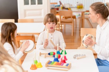 Anaokulu çocukları çeşitli renkli enstrümanlar kullanarak müzik öğreniyor. Çocuklar için Renkleri Kullanarak Müzik Öğrenmek. Anaokulu öğrencileri için Montessori Müzik Faaliyetleri.