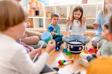 Müzik sınıfında enstrümanları olan anaokulu çocukları.