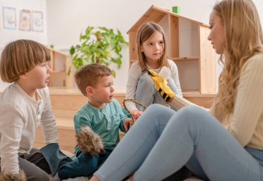 Anaokulundaki öğretmen kuklalarla oynuyor. 