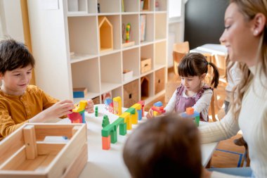 Anaokulu çocukları çeşitli renkli enstrümanlar kullanarak müzik öğreniyor. Çocuklar için müzik öğreniyorum. Anaokulu öğrencileri için Montessori Müzik Faaliyetleri.