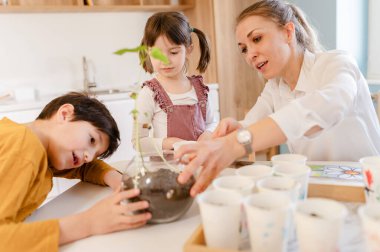 Çiçek eken çocuklu genç bir kadın