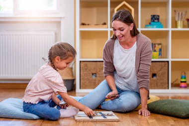 Anne bir çocukla Tak-Tak-Tak oynuyor. Çocuklar için eğitici oyunlar. Anne çocuklar birlikte yaratıcı zaman geçiriyorlar..
