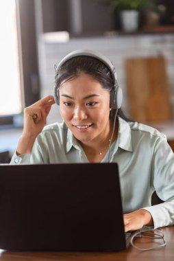 Genç, güzel Asyalı kadın internette öğreniyor.