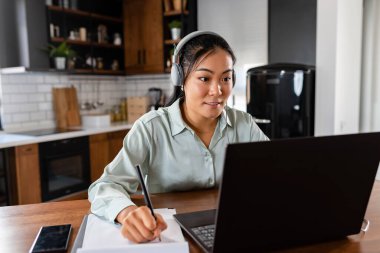 Genç, güzel Asyalı kadın internette öğreniyor.