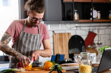 Yakışıklı genç adam yemek yapıyor.