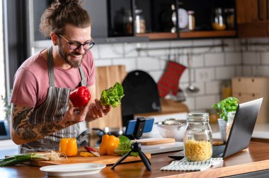 Yakışıklı genç adam yemek yapıyor.