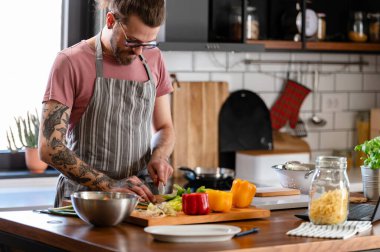 Yakışıklı genç adam yemek yapıyor.