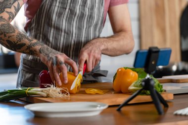 Yakışıklı genç adam yemek yapıyor.