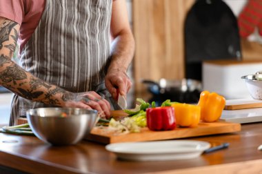 Yakışıklı genç adam yemek yapıyor.