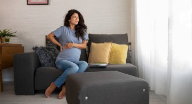 Güzel hamile kadın acıdan kıvranıyor.