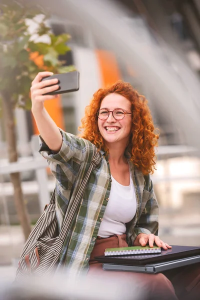 Улыбающаяся Рыжеволосая Студентка Делает Автопортрет Смартфоном Перед Зданием Университета — стоковое фото