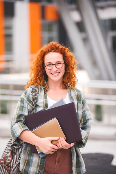 大学の建物の前に美しい笑顔の赤い髪の学生の女の子の肖像 — ストック写真