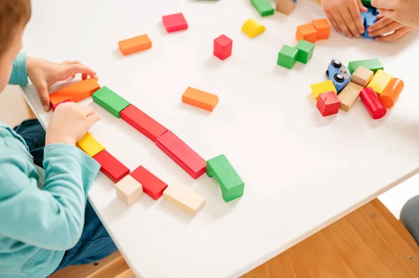 Barn Leker Med Färgglada Leksakstärningar Vid Ett Träbord — Stockfoto