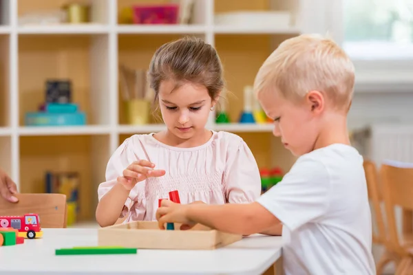 Para Dzieci Bawi Się Kolorowymi Drewnianymi Zabawkami Przedszkolu Skupiają Się — Zdjęcie stockowe