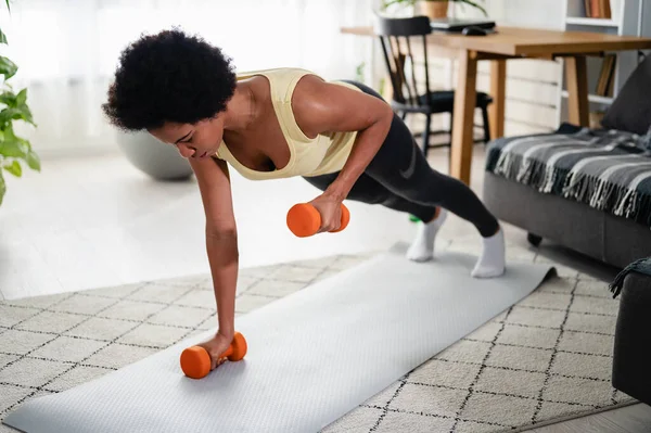 stock image African-American woman doing exercises on the floor at her home. Trying to stay healthy and fit.