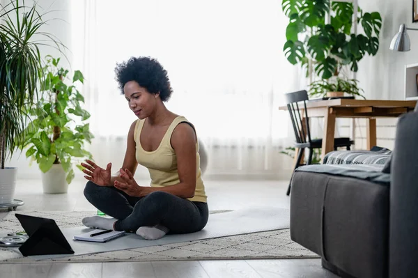 Afroamerikanerin Beim Online Yoga Fitnesskurs Hause Auf Dem Fußboden Sitzen — Stockfoto