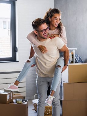 Mutlu çok ırklı çift yeni boş bir daireye taşındılar bavullarını boşaltıp, temizleyip, yeni evlerinin tadını çıkarıyorlar. Yeniden yerleştirme. İçeri giriyoruz..