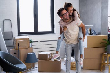 Mutlu çok ırklı çift yeni boş bir daireye taşındılar bavullarını boşaltıp, temizleyip, yeni evlerinin tadını çıkarıyorlar. Yeniden yerleştirme. İçeri giriyoruz..