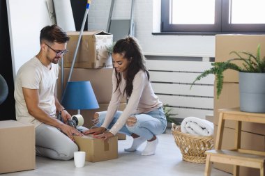 Mutlu çok ırklı çift yeni boş bir daireye taşındılar bavullarını boşaltıp, temizleyip, yeni evlerinin tadını çıkarıyorlar. Yeniden yerleştirme. İçeri giriyoruz..