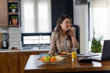 Genç ve güzel bir kadın evde çalışıyor.