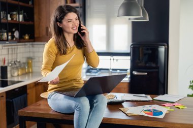 Genç ve güzel bir kadın evde çalışıyor.