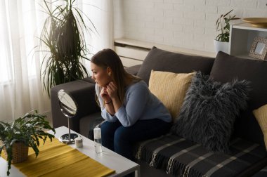 Evdeki aynada kendine bakan genç ve güzel bir kadın. Sivilceler için endişeleniyorum. Sivilcelerle ilgili sorunlar.