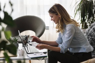 Genç, güzel, gülümseyen bir kadın kredi kartıyla online ödeme yapıyor. Çevrimiçi bankacılık.
