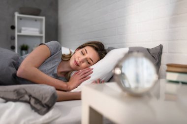 Sabahın köründe yatakta uyuyan güzel bir genç kadın rüya görüyor.