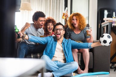 Bir grup arkadaş futbol izleyip bira içiyorlar.