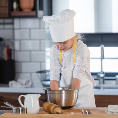 Sevimli genç kız evde yemek pişiriyor.