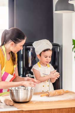 Anne oğluyla yemek yapıyor. Hamurla çalışmak