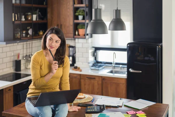 家で働く若い笑顔の実業家は 彼女のラップトップ上のコンピュータで自宅のキッチンに座って — ストック写真