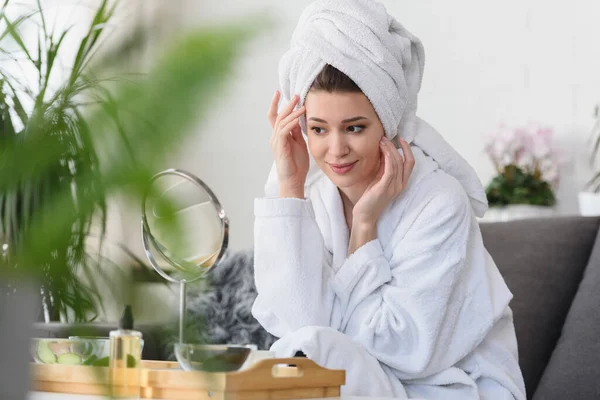 一个年轻貌美的女人穿着浴衣在家的画像 用天然化妆品做日常护肤工作 — 图库照片