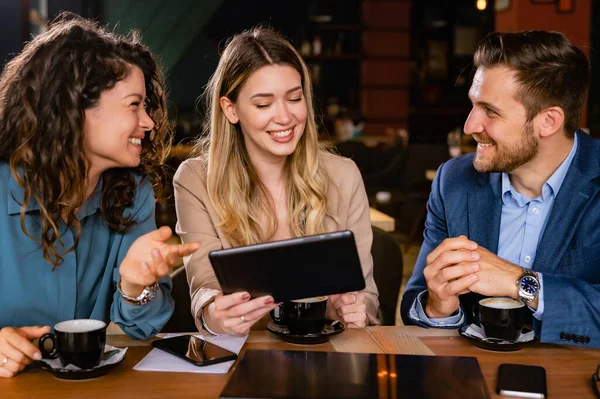 Duas Mulheres Jovens Homem Usando Tablet Sorrindo Enquanto Sentado Café — Fotografia de Stock
