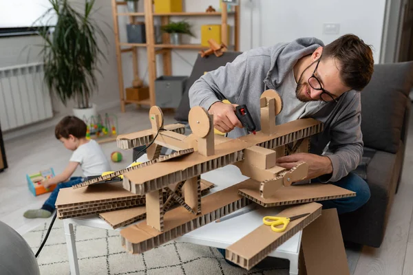 stock image father making wooden plane for his son