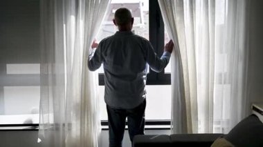 Pencereden bakan yaşlı bir adam.