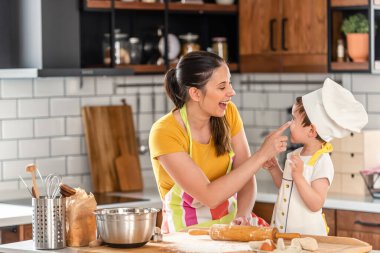Anne oğluyla yemek yapıyor. Hamurla çalışmak