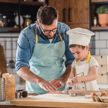 Baba oğluyla yemek pişiriyor.