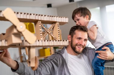 Baba ve oğul tahta uçak yapıyorlar.