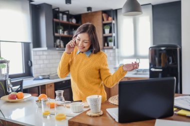 Ev ofisinde dizüstü bilgisayarla çalışan serbest çalışan bir kadın. Esnek çalışma alanı ve çalışma zamanı.