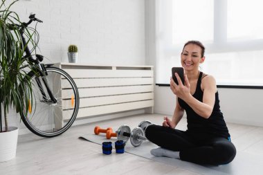 Sabahları evde akıllı telefon kullanan bir kadın.