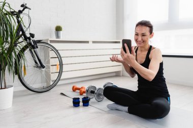 Sabahları evde akıllı telefon kullanan bir kadın.