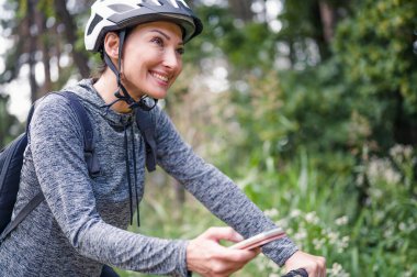 Ormanda bisiklet süren genç bir kadın. 