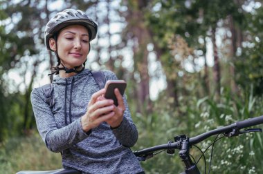 Ormanda bisiklet süren genç bir kadın. 
