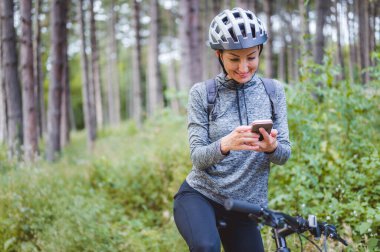 Ormanda bisiklet süren genç bir kadın. 