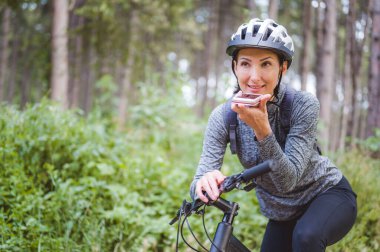 Ormanda bisiklet süren genç bir kadın. 